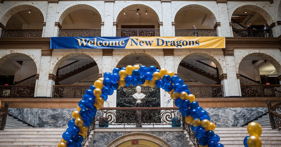 Blue and gold balloon arch with a banner that says "Welcome New Dragons!"